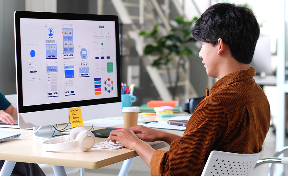 Designer working on website layouts at a desktop computer
